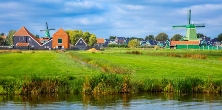 Panoramic view of a Dutch village with windmills, green houses pastures and meadows. Agricultural landscape. Tourism. Holland, Netherlands, Europe.のeditorial素材