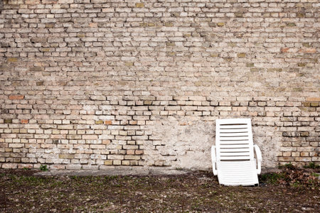 Aged wall and a broken plastic chairの写真素材