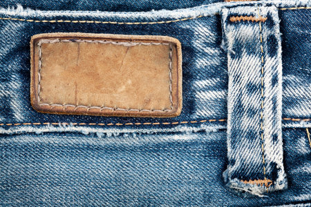 Blank leather jeans label sewed on a blue jeans.