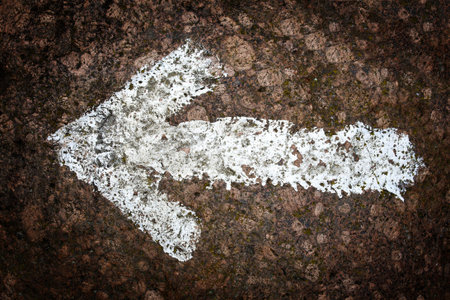 White arrow painted on a rockの写真素材