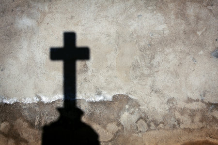 Shadow of a cross on a wallの写真素材