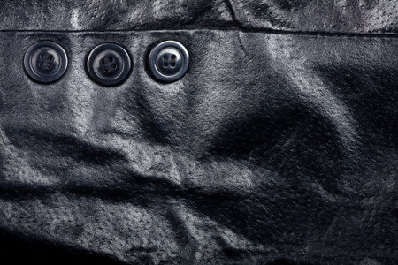 Fragment of black leather jacket with some buttonsの写真素材