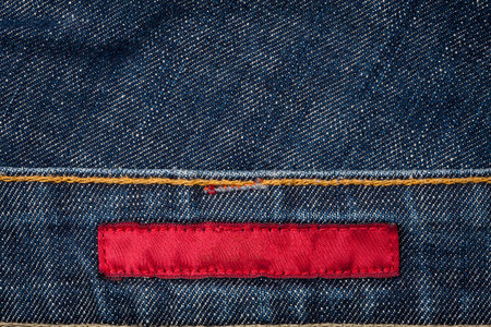 Blank red fabric jeans label sewed on a blue jeans.の写真素材