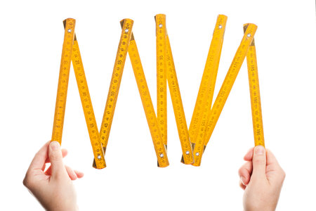 Hands holding wooden folding  ruler isolated on white