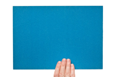 Blue rough paper in woman hand isolated on white background  の写真素材