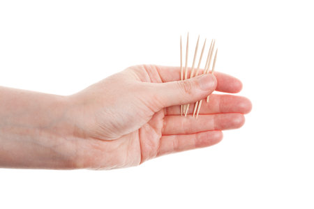 Toothpicks in hand isolated on white background の写真素材
