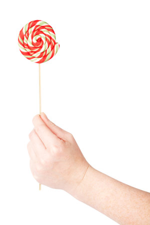 Hand holding colorful spiral lollipop isolated on white backgroundの写真素材