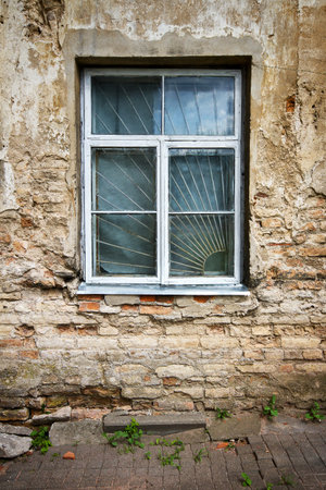 Old cracked wall with a window  