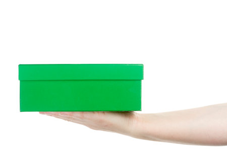 Female hand holding cardboard box isolated on white backgroundの写真素材