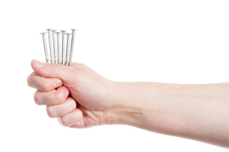 Hand holding handful of nails isolated on whiteの写真素材