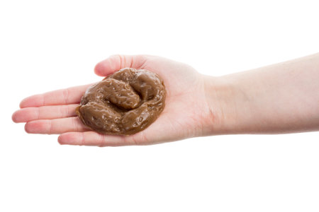 Hand holding fake rubber excrement isolated on white background の写真素材