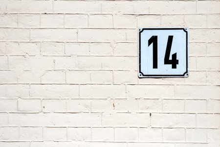 Number 14 on textured brick wall