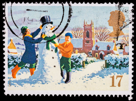  A stamp printed in the United Kingdom shows children making a snowmanの写真素材