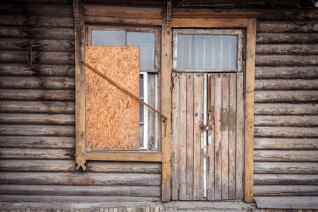 Boarded up windows and old door of a abandoned houseの写真素材