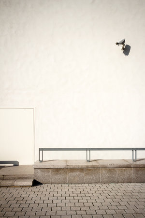 White wall with security camera on a sunny day