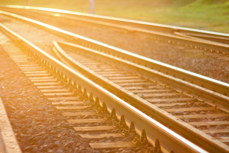 Curved railroad tracks in sunset