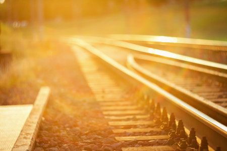 De focused curved railroad tracks in sunset with a lens flareの写真素材