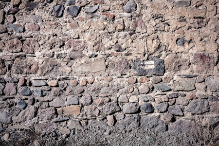 Old weathered wall of stones and a ground