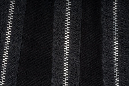 Zippers on black fabric, abstract backgroundの写真素材