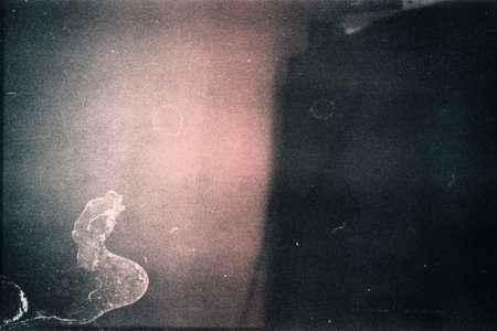 Designed film texture background with heavy grain, dust and a light leakの写真素材