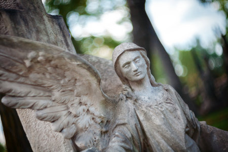 Old concrete statue of angel at Rasu cemetery in Vilnius Lithuania. Shot taken with a soft focus lens, shallow depth of field.の写真素材