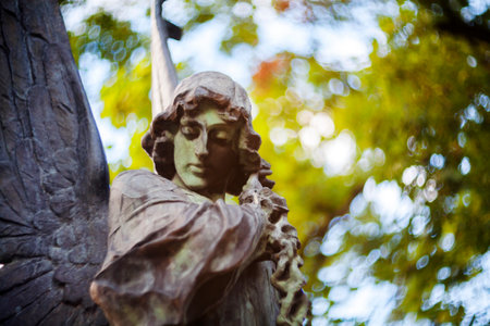 Old bronze statue of angel at Rasu cemetery in Vilnius Lithuania. Shot taken with a soft focus lens, shallow depth of field.の写真素材