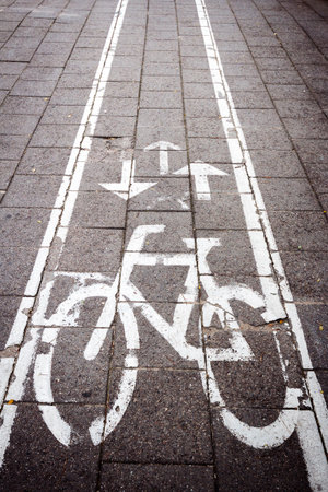 Bicycle road sign painted on the old concrete tile pavementの写真素材