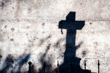 Shadow of a cross on a concrete wallの写真素材