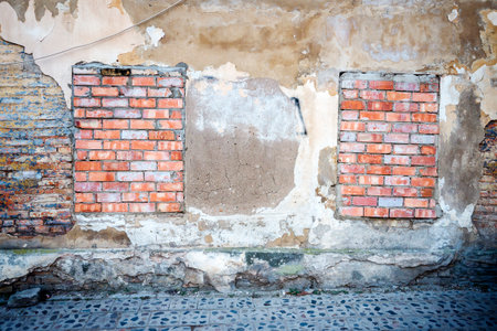 Old gungy wall with bricked up windowsの写真素材