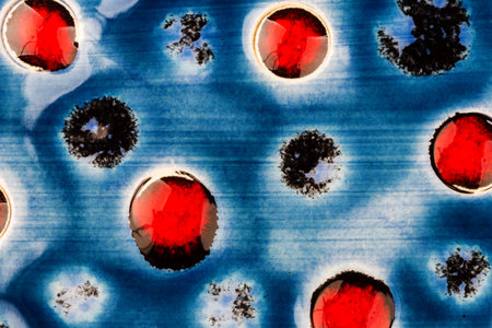 Closeup shot of glazed blue with red dots ceramics texture