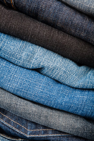 Stack of blue jeans as a background or textureの写真素材