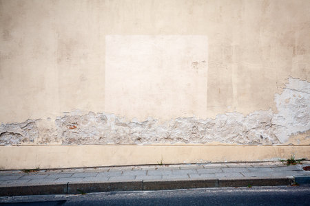 Old cracked yellow wall and pavementの写真素材