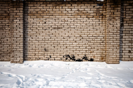 White brick wall and a ground covered with snowの写真素材