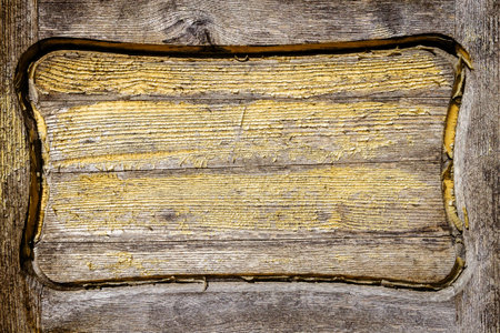 Closeup shot of old wooden door detail with peeling yellow paintの写真素材