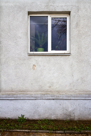 Old white street wall with a window