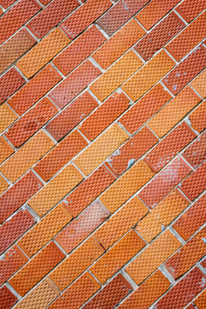 Background of old red and dotted brick wall texture, abstract vertical architecture wallpaperの写真素材