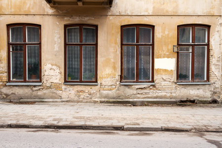 Aged weathered street wall with some windows. Architectural detail backgroundの写真素材