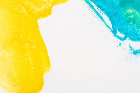 Macro shot of abstract hand drawn blue and yellow watercolor paints backgroundの写真素材