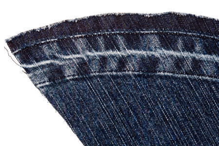 Piece of dark blue jeans fabric isolated on white background. Rough uneven edges.