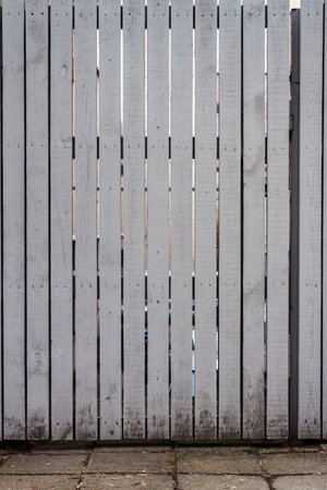 Old weathered gray wood plank fence and a groundの写真素材