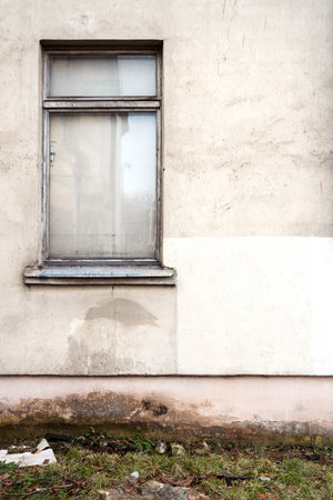 Gray plaster wall with a window. Architecture detail backgroundの写真素材