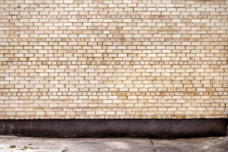 Yellow brick wall background with concrete basement. Architecture detail backgroundの写真素材