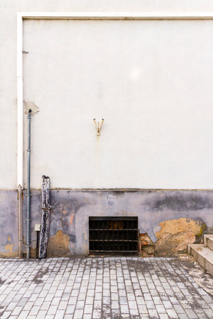 Old grungy white and blue wall, stairs, window and pavement