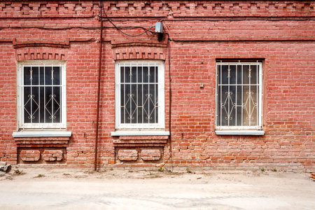 Aged weathered street wall with three windowsの写真素材