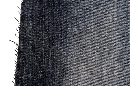 Piece of dark jeans fabric isolated on white background. Rough uneven edges.