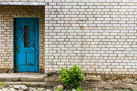 Old blue door on a white brick wall. Old house white wall with blue door. Architecture detail backgroundの写真素材