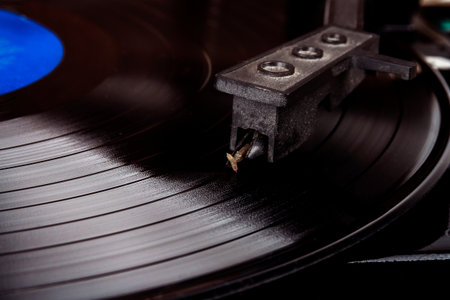 Turntable stylus on a vinyl record. Vintage vinyl record player. Needle on a black vinyl record.