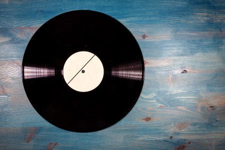 Black color vinyl record with white label on blue wooden backgroundの写真素材