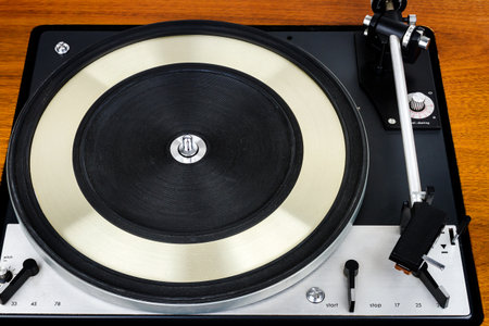 Close up of vintage turntable vinyl record player. Wooden plinth. Retro audio equipment.