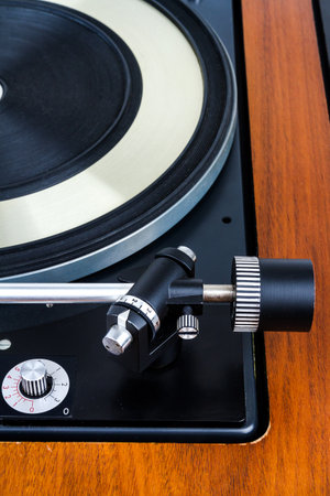 Side view of vintage turntable vinyl record player isolated on white. Wooden plinth. Retro audio...
